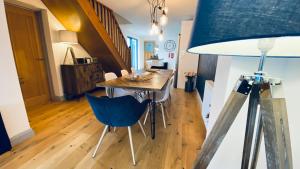 ein Esszimmer mit einem Tisch und einem blauen Stuhl in der Unterkunft Tregenna House - St Ives, A Beautiful Newly Refurbished 4 Bedroom Family Town House With Alfresco Dining Garden and Private Parking Spaces in St Ives