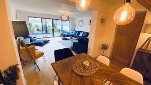 a living room with a dining table and a living room with a couch at Tregenna House - St Ives, A Beautiful Newly Refurbished 4 Bedroom Family Town House With Alfresco Dining Garden and Private Parking Spaces in St Ives