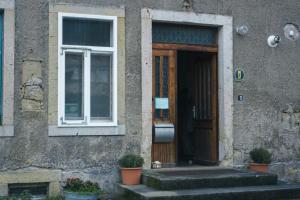 una porta per un edificio con piante in vaso di fronte di FEWO natuerlich-wolf a Königstein