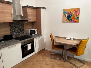 S&E Apartments Vienna في فيينا: مطبخ صغير مع طاولة وميكروويف
