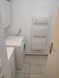bagno bianco con lavatrice e finestra di Appartement proche aéroport Orly ad Athis-Mons