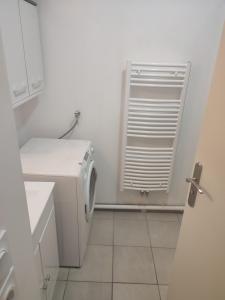 a white bathroom with a washing machine and a window at Appartement proche aéroport Orly in Athis-Mons