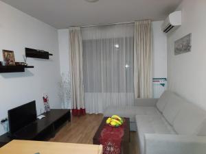 Una sala de estar con un sofá blanco y una mesa. en Apartament 4 seasons - Top Lodge, en Bansko