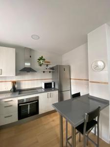 a kitchen with a table and a stainless steel refrigerator at Apartamento ANY in Benaoján