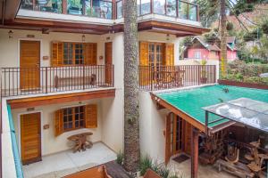 an image of a house with a swimming pool at La Brume Pousada in Campos do Jordão