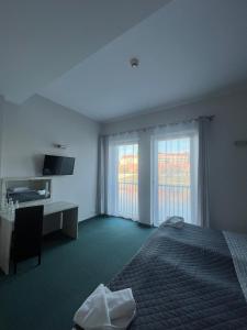 um quarto de hotel com uma cama, uma secretária e uma janela em Hotel Poleski na Cracóvia