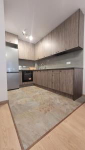 uma grande cozinha com armários de madeira e um frigorífico de aço inoxidável em Apartament "Cztery Pory Roku" em Świdnik