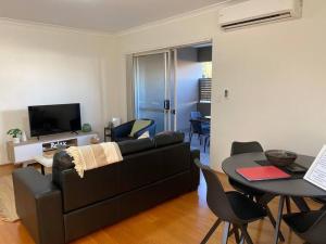 sala de estar con sofá y mesa en Smart Modern Close City/Airport WIFI/Park/Netflix en Perth