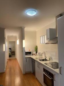 uma cozinha com um lavatório e uma bancada em Smart Modern Close City/Airport WIFI/Park/Netflix em Perth