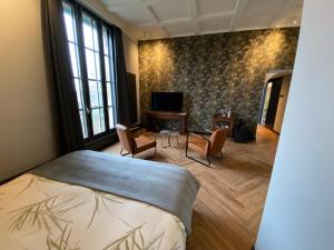 - une chambre avec un lit, une table et des chaises dans l'établissement Atalanta-Wellness Roermond 'de Wethouder', à Herten