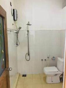 a bathroom with a shower and a toilet and a phone at Hotel Siyathma polonnaruwa in Polonnaruwa