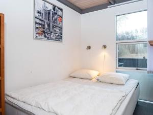 エーベルトフトにある8 person holiday home in Ebeltoftの白いベッドルーム(窓付きのベッド付)
