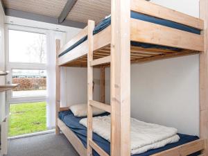 エーベルトフトにある8 person holiday home in Ebeltoftの二段ベッド2組、窓が備わる客室です。