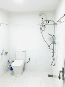 a white bathroom with a toilet and a shower at Hotel Siyathma polonnaruwa in Polonnaruwa