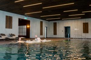 two people in the water in a swimming pool at Grand Hotel du Cervin - Auberge de jeunesse et spa in Saint-Luc