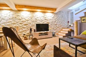 uma sala de estar com uma parede de pedra em Holiday Home Taraš em Smilčić