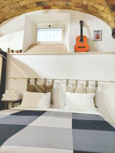 1 dormitorio con 1 cama con una guitarra en la pared en Trastevere in Music, en Roma