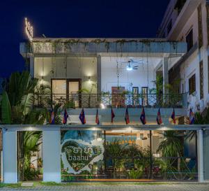 a building with a balcony with flags on it at Baahu Villa in Siem Reap