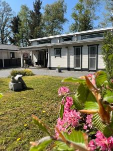 ein weißes Haus mit Blumen davor in der Unterkunft Villa Bartje in Schoonebeek