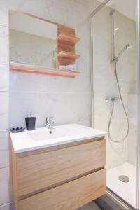 een badkamer met een witte wastafel en een douche bij L'ELEBASCH - Studio confort Netflix/Prime Vidéo in Riom