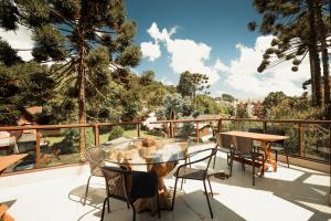 坎普斯杜若爾當的住宿－La Brume Trailers，阳台配有玻璃桌、椅子和树木