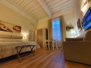 um quarto com uma cama, um sofá e uma televisão em RF Duomo suites em Florença