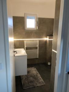 ein Bad mit einem Waschbecken und einem Fenster in der Unterkunft Apartments Villa Prima in Privlaka