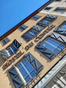una señal en el lateral de un edificio con ventanas en Chambre d'hôtels, en Champeix