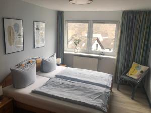 1 dormitorio con 1 cama con ventana y silla en Grandezza Ferienwohnungen Erpeldinger, en Ellenz-Poltersdorf