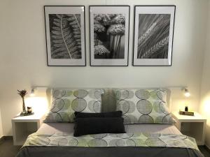 ein Schlafzimmer mit einem Bett mit drei Bildern an der Wand in der Unterkunft Apartments Villa Prima in Privlaka