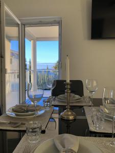einen Esstisch mit Weingläsern und einer Kerze in der Unterkunft Apartments Villa Prima in Privlaka