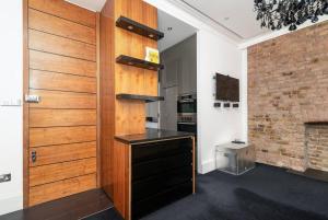 een keuken met een houten muur naast een open haard bij Award-winning designer apartment in Londen