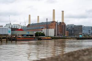 een uitzicht op een grote fabriek aan de rivier bij Award-winning designer apartment in Londen