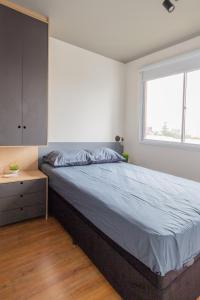 a bedroom with a large bed and a window at Conforto e Aconchego na Zona Sul in Sao Paulo