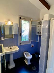 Baño azul con lavabo y aseo en Faraway's Bed & Breakfast en Los Cocos