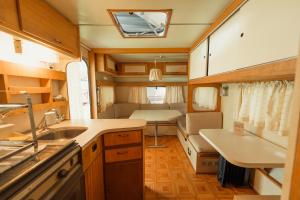 a kitchen with a sink and a table in a trailer at La Brume Trailers in Campos do Jordão