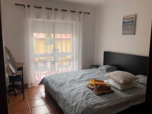 a bedroom with a bed and a window with a table at Fuzeta Lovers Apartment in Fuzeta