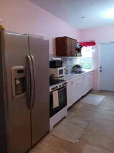 a kitchen with a stainless steel refrigerator and a stove at Mountain and Sea view Stay in Sandy Point Town