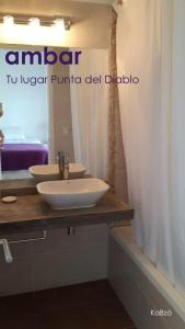 Baño con 2 lavabos y espejo en una encimera en Casa Ambar, vista al mar, Punta del Diablo,Uruguay, en Punta del Diablo