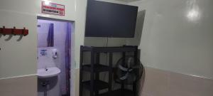 a bathroom with a washing machine and a tv on the wall at HOTEL NUEVO GALEX in Acacías +39 photos