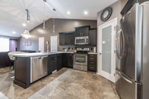 a kitchen with stainless steel appliances and a counter top at Modern House Fenced Back Yard BBQ Garage in Lloydminster