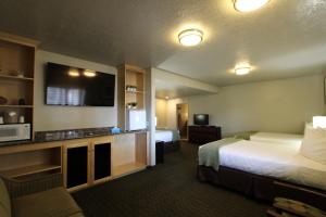 um quarto de hotel com duas camas e uma televisão de ecrã plano em Dinosaur Inn & Suites em Vernal