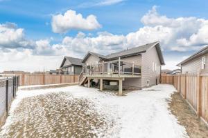 a house with a deck and a fence at Modern House Fenced Back Yard BBQ Garage in Lloydminster