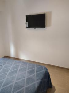 - une chambre avec un lit et une télévision à écran plat dans l'établissement departamento tandil centro, à Tandil