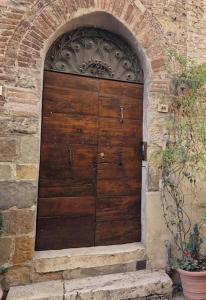 eine große Holztür in einem Backsteingebäude in der Unterkunft La Finestra Sul Corso in Montepulciano