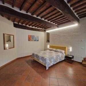 ein Schlafzimmer mit einem großen Bett in einem Zimmer in der Unterkunft La Finestra Sul Corso in Montepulciano