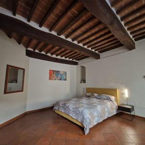 ein Schlafzimmer mit einem großen Bett und einer Holzdecke in der Unterkunft La Finestra Sul Corso in Montepulciano
