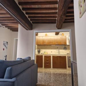 ein Wohnzimmer mit einem Sofa und einer Küche in der Unterkunft La Finestra Sul Corso in Montepulciano