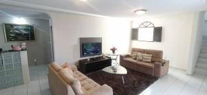 a living room with two couches and a table at POUSADA VENTO NORTE CAMA & CAFÉ SUÍTES INDIVIDUAIs in João Pessoa