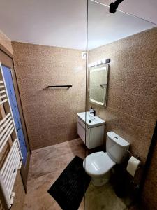 a small bathroom with a toilet and a mirror at Camera/garsoniera in regim hotelier in Comăneşti